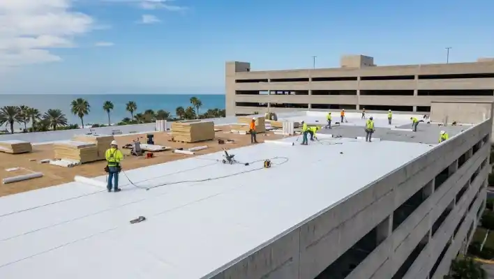 Commercial roofing crew laying down a white TPO flat roof membrane and insulation on a new commercial building construction in Clearwater FL.