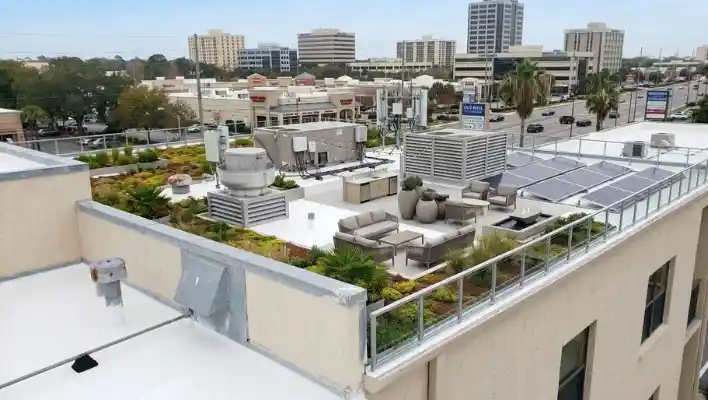 Wide view of a modern commercial flat roof featuring a green roof layout, solar panels, and commercial HVAC equipment in Clearwater FL.